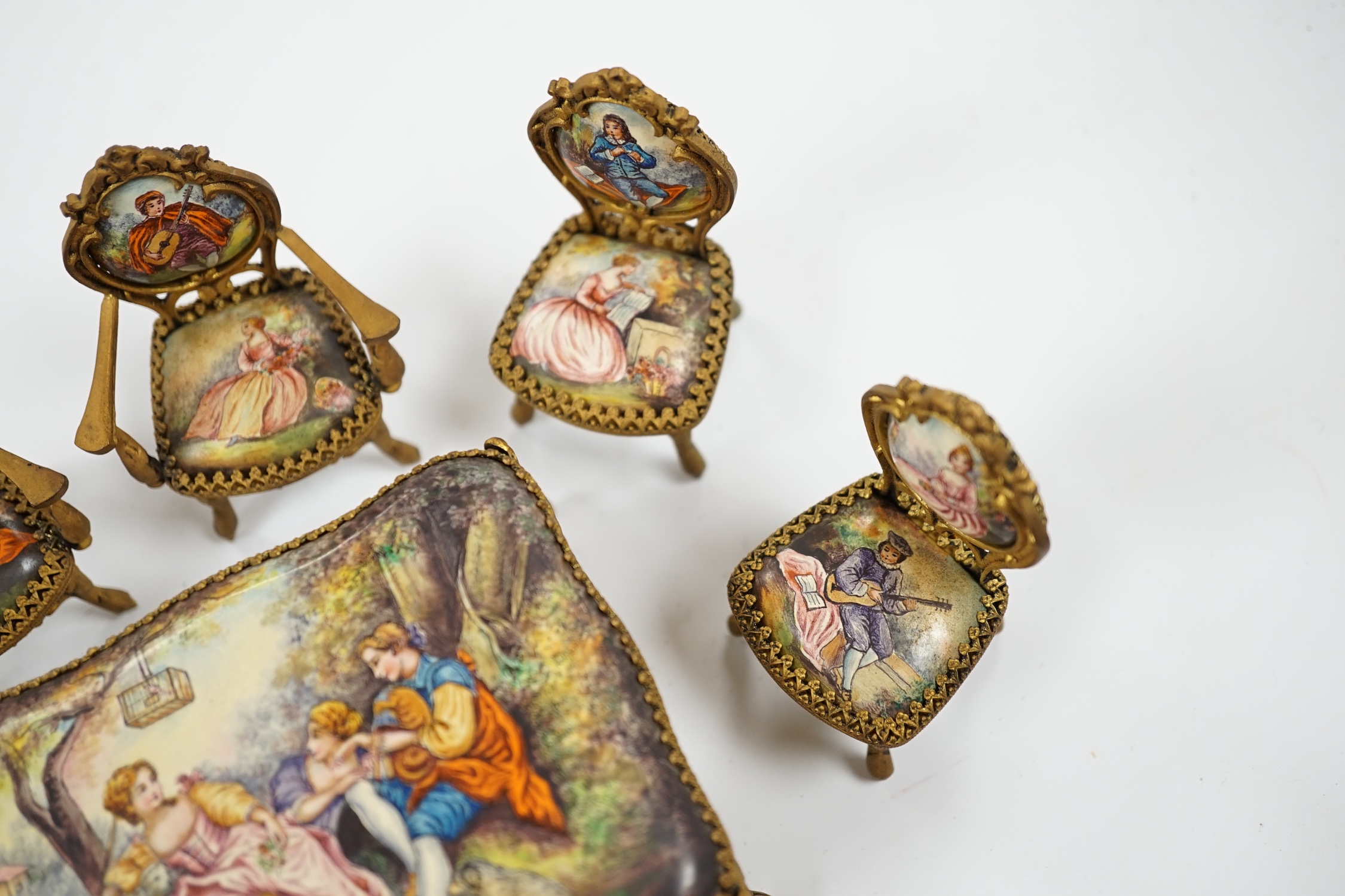 An early 20th century miniature enamel and gilt metal framed furniture set, possibly Austrian, largest 9cm wide. Condition - fair